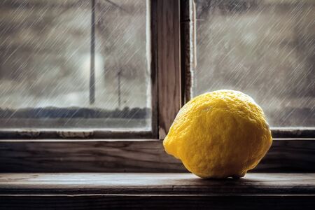 Single lemon sitting on threshold of a rustic windowの写真素材