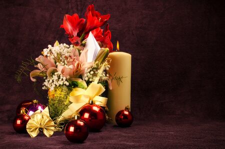 Christmas baubles with flower and candle on red backgroundの写真素材