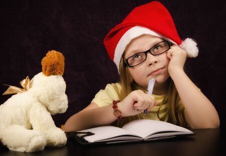 Girl who thinks what to write to Santa Clausの写真素材