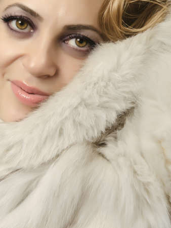 Close up of a beautiful women wearing a fur coat and looking at camera