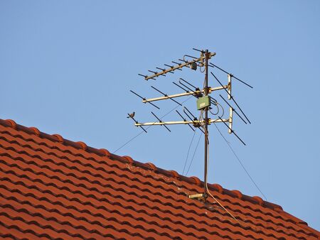 receiver antenna on red roof in sunlightの写真素材
