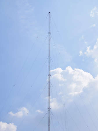 high communication pole on cloudy sky and sunlight