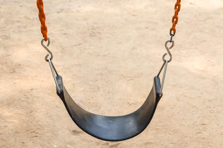 black seat and red chain of swing in playgroundの写真素材