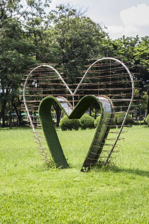 green heart shape bower on lawn, Lumphini Park, Bangkok Thailand.の写真素材