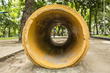 yellow concrete pipe as tunnel of playground in Lumpini park, Bangkok, Thailandの写真素材