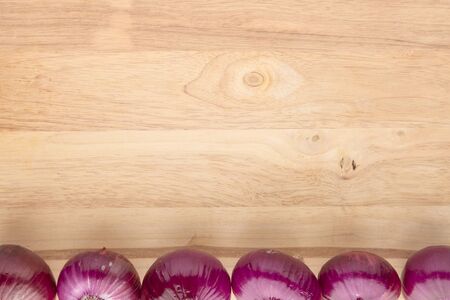 array of fresh shallots on edge on wooden backgroundの写真素材