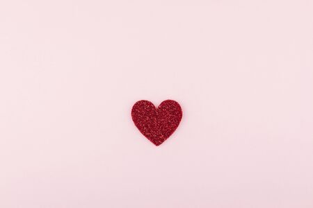 piece of glitter red heart decorate on pink paper backgroundの写真素材