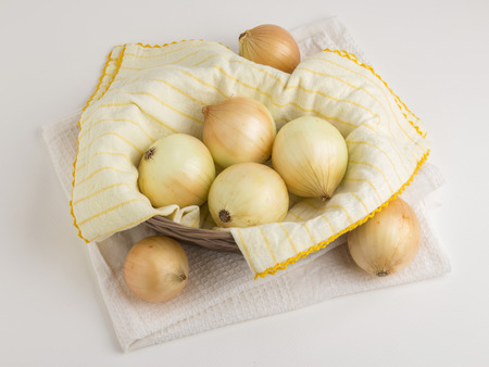 onions in basket with dish towel decoration on white backgroundの写真素材