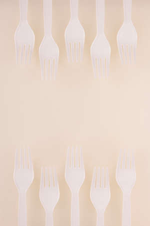 white plastic fork zigzag border decoration on white board backgroundの写真素材