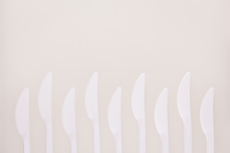 white chopping board background by white plastic knife zigzag array decorationの写真素材