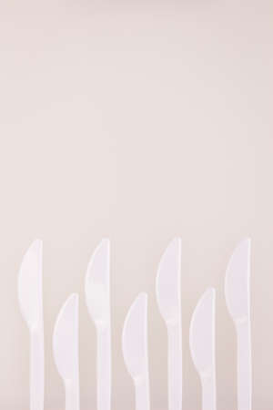 white plastic knife zigzag array decoration on white board backgroundの写真素材