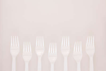 white chopping board background by white plastic fork zigzag array decorationの写真素材