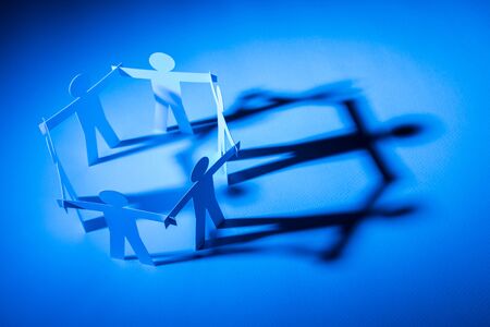 closed joining of six paper figure on blue light background. in concept of business, cooperation and...