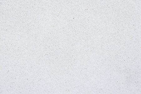 background of white fine gravel stone wall in sunlightの写真素材