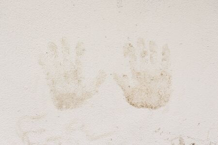 close up or dirty handprints stained on white wall in nature light