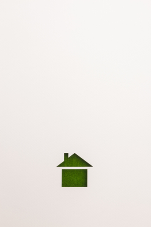 white background of paper cutout in basic house shape by green velvet sheet, for ecology and energy conceptual.の写真素材