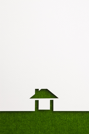 white paper cutout in easy house shape with border background by green flannel, for ecology and energy conceptual.の写真素材