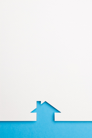 white paper cutout in simple house shape with border background by blue paper, for home and insurance conceptual.の写真素材