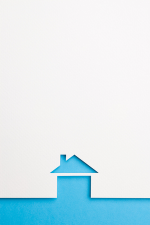 white paper cutout in basic house shape with border background by blue paper, for home and insurance conceptual.の写真素材