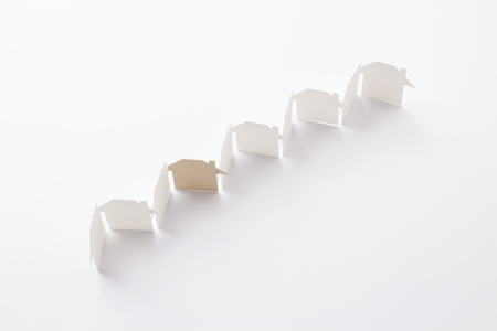 top view of line linked of paper cutout houses with brown one on white background, for home and ecology conceptual, selective focused.の写真素材