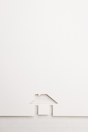 white paper cutout in easy house shape with border background by notepaper, for home and insurance conceptual.の写真素材