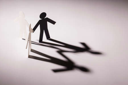 black figure in all in one link of three both hand down paper figure on light background. in concept of business, teamwork and weakness.の写真素材
