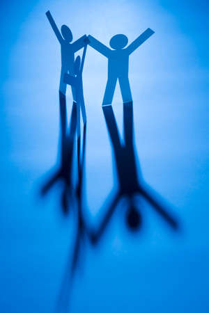 view of all in one joining of three both hand up paper figure on blue light background. in concept of business, successful and freeの写真素材