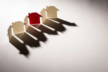 red one in line link of simple paper house in light with shadow on white texture paper background in concept of business and banking. selective focus point.の写真素材