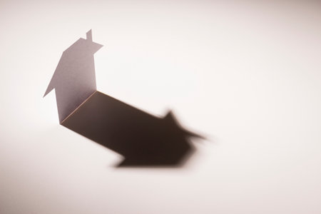 white paper cutout in plain house shape stand on light with shadow on white background, in concept of business banking and insurance.の写真素材