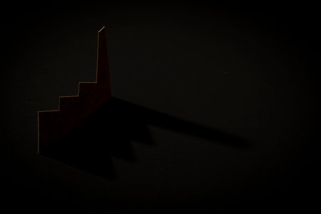 brown color paper cutout in plain factory shape stand on light with shadow on black background, in concept of industrial environment and sustainability.の写真素材