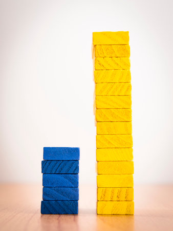 high - low two step bar graph of stack color wooden toy blocks on white background, compair between...