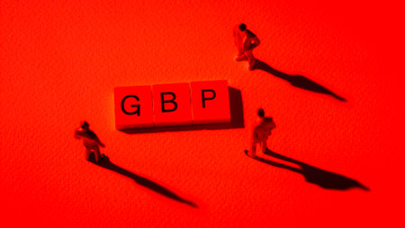 Miniature figures businessman with shadow : meeting on GBP word by wooden block words in red light background, in concept of risk, critical and recessionの写真素材