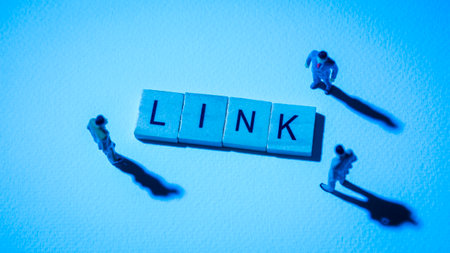 Miniature figures businessman : meeting on LINK word by wooden block words on white paper background in blue light, LINK or Chainlink in concept of digital money, cryptocurrency and business.の写真素材