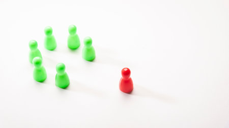 circle arrangement of seven green plastic pin with out of position of red one on white background,...