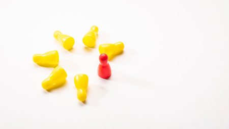 standing one of red pin in circle arrangement of seven yellow fallen pin on white background, in concept of difference.の写真素材