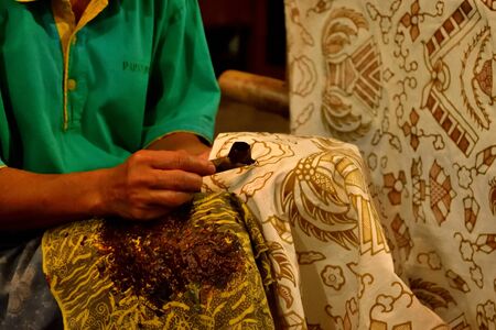Closeup of a worker who paints Batik fabric, Indonesiaの写真素材