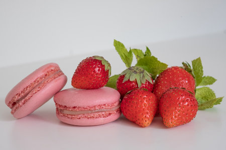 Strawberry macaroons and strawberries on a white background.の写真素材