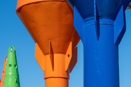 Close-up of colorful water pipes, buoys against the blue sky, vertical