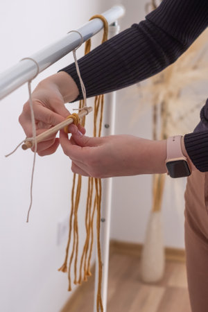 Woman's hands weave macrame decor. handicraft advertisement. copyspace. high quality photoの写真素材
