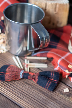 Lumberjack set with metal cup, red black checkered bow and matches. Copy space. High quality photoの写真素材