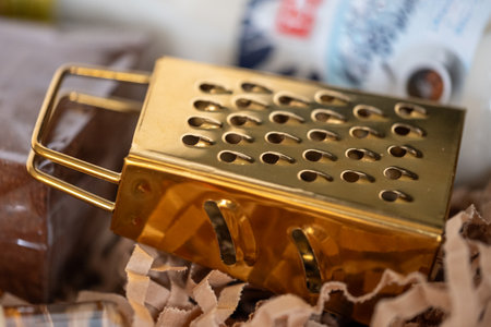 A small gold grater in a stack of sustainable shredded paper in a package. Copy space. High quality photoの写真素材