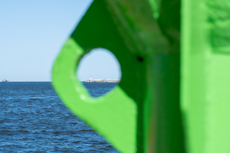 A durable green metal structure with a part like round hole through which the mobile floating platform can be seen in the sea. Copy space. Background for quotes. High quality photoの写真素材