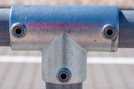 Metal pipe fastening with threads. In the background, a white stripe is painted on a light pavement in sunny summer day. Copy space. Background for quotes. High quality photoの写真素材