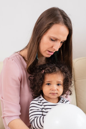 A tender moment between a mother and her mixed-race child a portrait of maternal care and gentle guidance, or child therapy with toys. High quality photoの写真素材