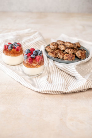 Gourmet meatballs on a rustic plate with a parfait of berries, embodying a casual yet tasteful culinary setup. High quality photoの写真素材