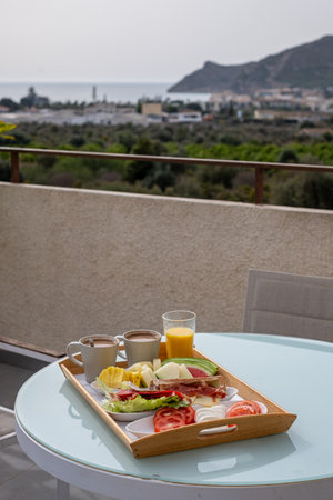 A tranquil breakfast with ocean view, featuring a tray of sandwiches and fresh fruit, perfect for depicting vacation mornings. High quality photoの写真素材