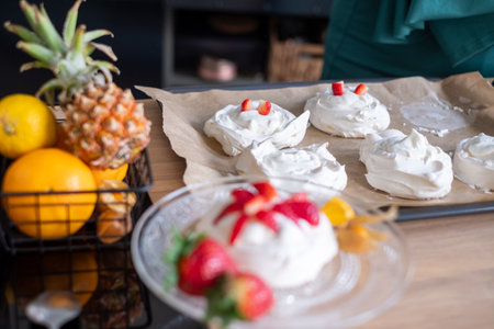 Pavlova dessert with fresh fruit on wooden surface, tropical fruits visible. Great for food magazines. High quality photoの写真素材