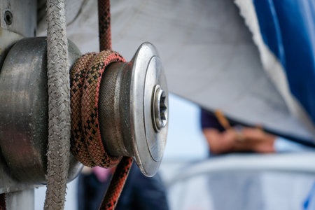 Metal winch features textured rope on a sailboat, highlighting construction details and sailing elements, creating an engaging atmosphere for marine enthusiastsの写真素材