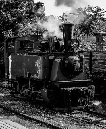 Old steam locomotive on the railroad. Black and white photo.