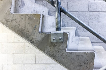 Side view of a set of concrete stairs, with a breeze block wall in the backgroundの写真素材